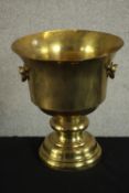 A large early 20th century brass twin handled urn on stepped pedestal base. H.33 Dia.30cm.