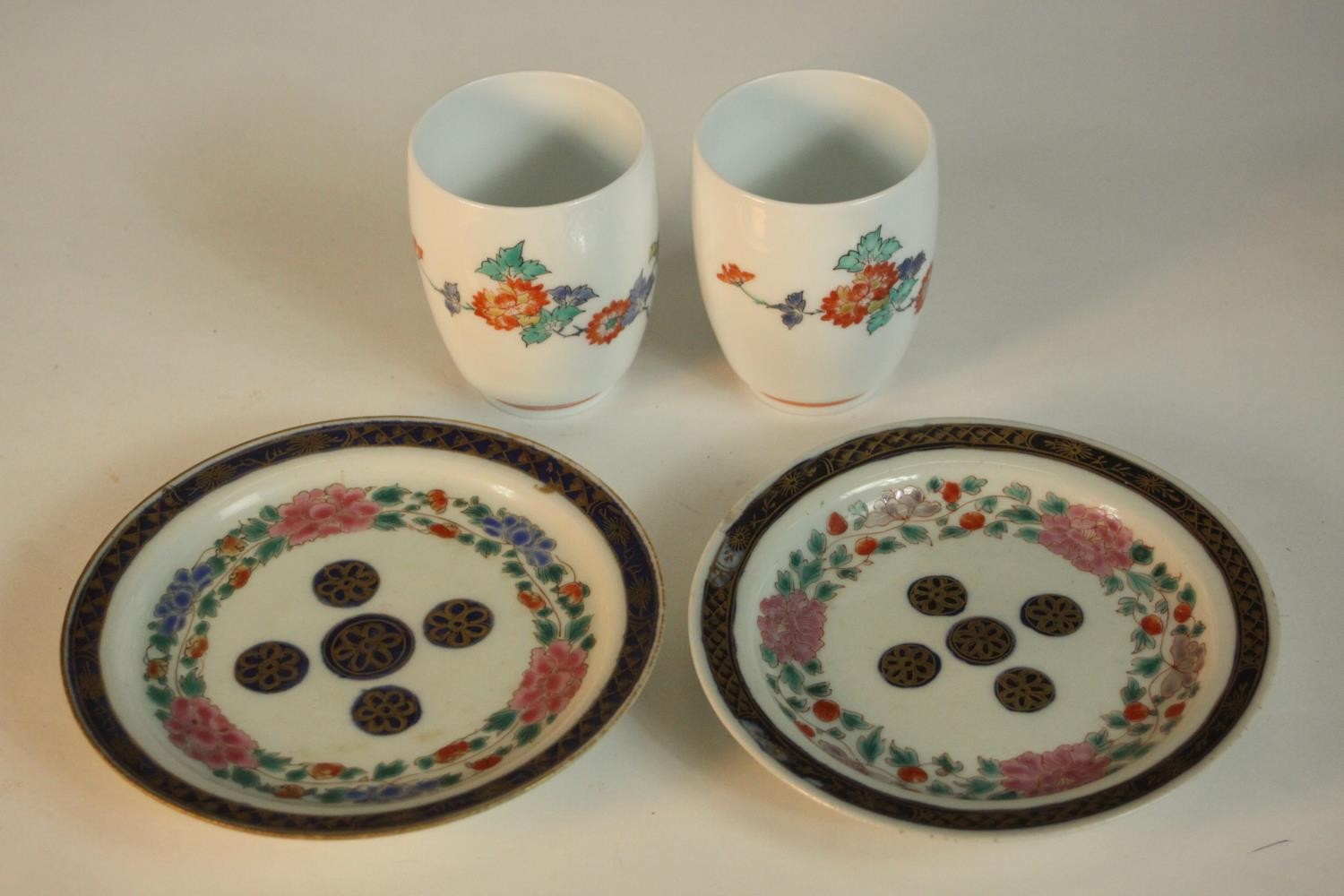 A pair of Japanese Kakiemon floral design porcelain cups, signed to base along with a pair of 19th