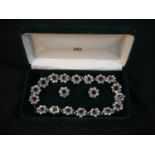 A vintage cased statement red and clear paste set flower design necklace and clip earrings.