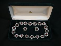 A vintage cased statement red and clear paste set flower design necklace and clip earrings.