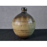 A green and brown glazed art pottery vase of bulbous form monogrammed to the base. H.26cm