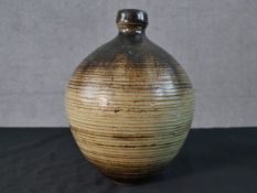 A green and brown glazed art pottery vase of bulbous form monogrammed to the base. H.26cm