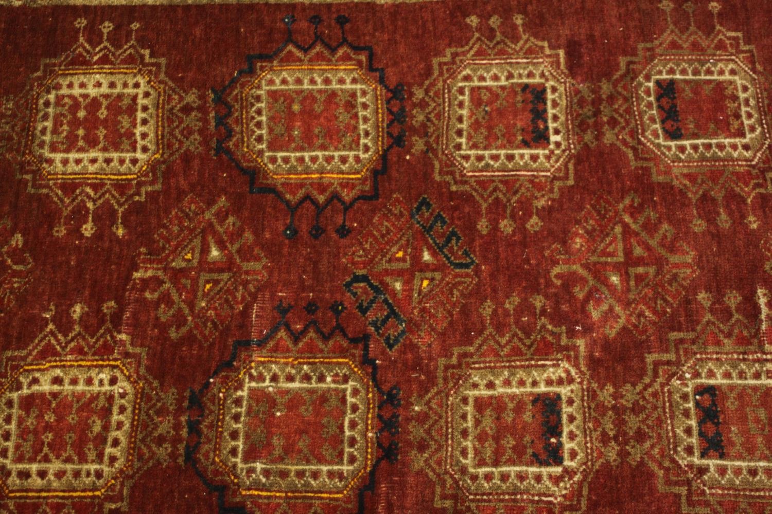 A hand woven Meshed carpet with repeating medallions on a burgundy field. L.210 W.113.cm. - Image 3 of 4
