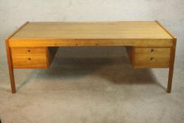 A circa 1970's Danish design inspired teak executive desk, the rectangular top over two pairs of