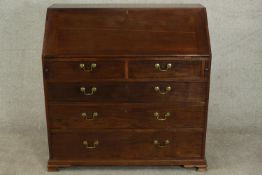 A 19th century mahogany bureau, the fall front enclosing a green writing surface with an arrangement