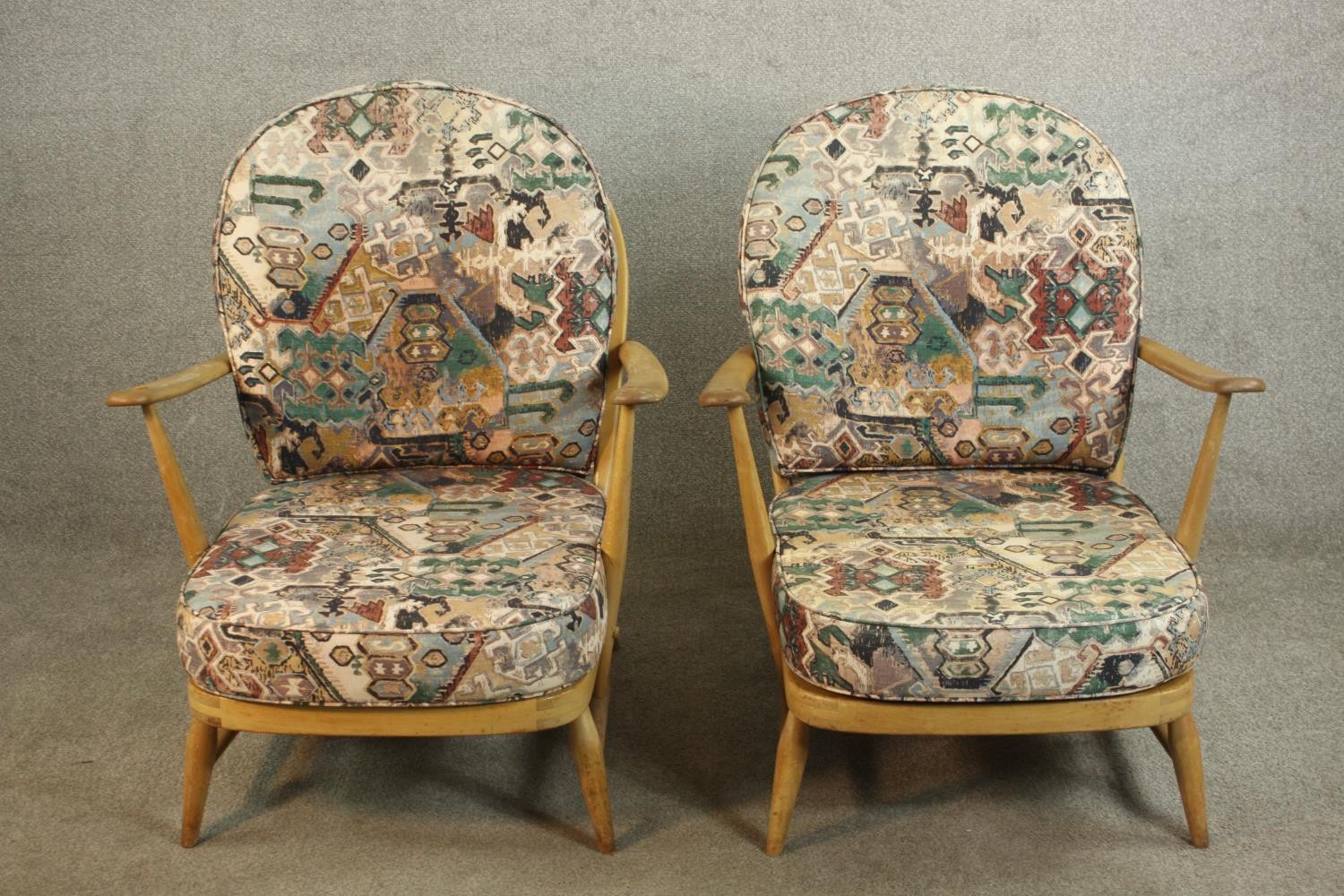 A pair of Ercol elm and beech hoop back armchairs, in Windsor style, with loose back and seat