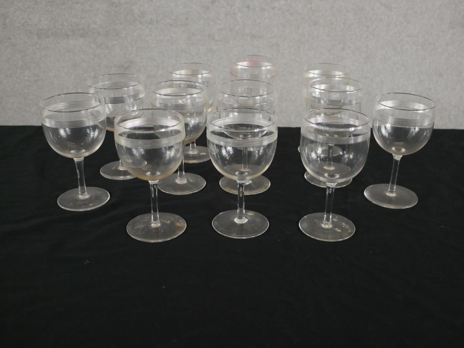 A set of twelve Victorian engraved stemmed glasses with horizontal line detailing. H.12 Dia.7cm.