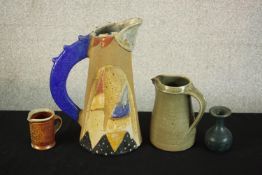 Three art pottery jugs and a blue glaze vase. One jug with abstract design by Jill Fanshawe-Kato