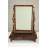A 19th century mahogany toilet mirror with a rectangular mirror plate on turned columns over two