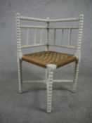 A late 19th century white painted corner chair, with a woven seat, on bobbin turned and