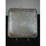 A large square Continental silver tray with pierced foliate and relief floral border. Stamped 900.