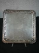 A large square Continental silver tray with pierced foliate and relief floral border. Stamped 900.