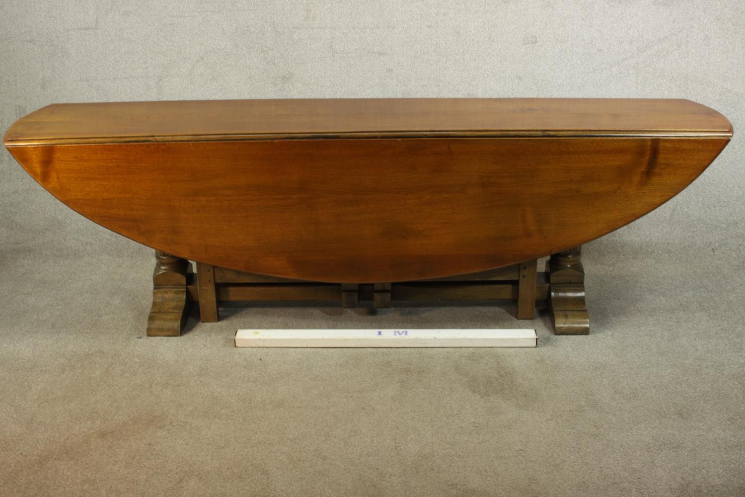 A 20th century oak drop leaf wake table, the oval top with two drop leaves raised on gate legs and - Image 2 of 12