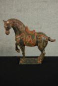 A Chinese Tang style painted ceramic horse on rectangular base. (Broken ear.) H.39 W.43 D.14cm.
