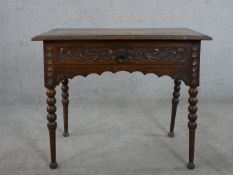 A Victorian carved oak lowboy, the top with a brown leather insert and a carved moulded edge over
