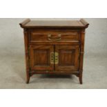 A late 20th century Chinese elm altar style cabinet, with a long drawer over two cupboard doors with