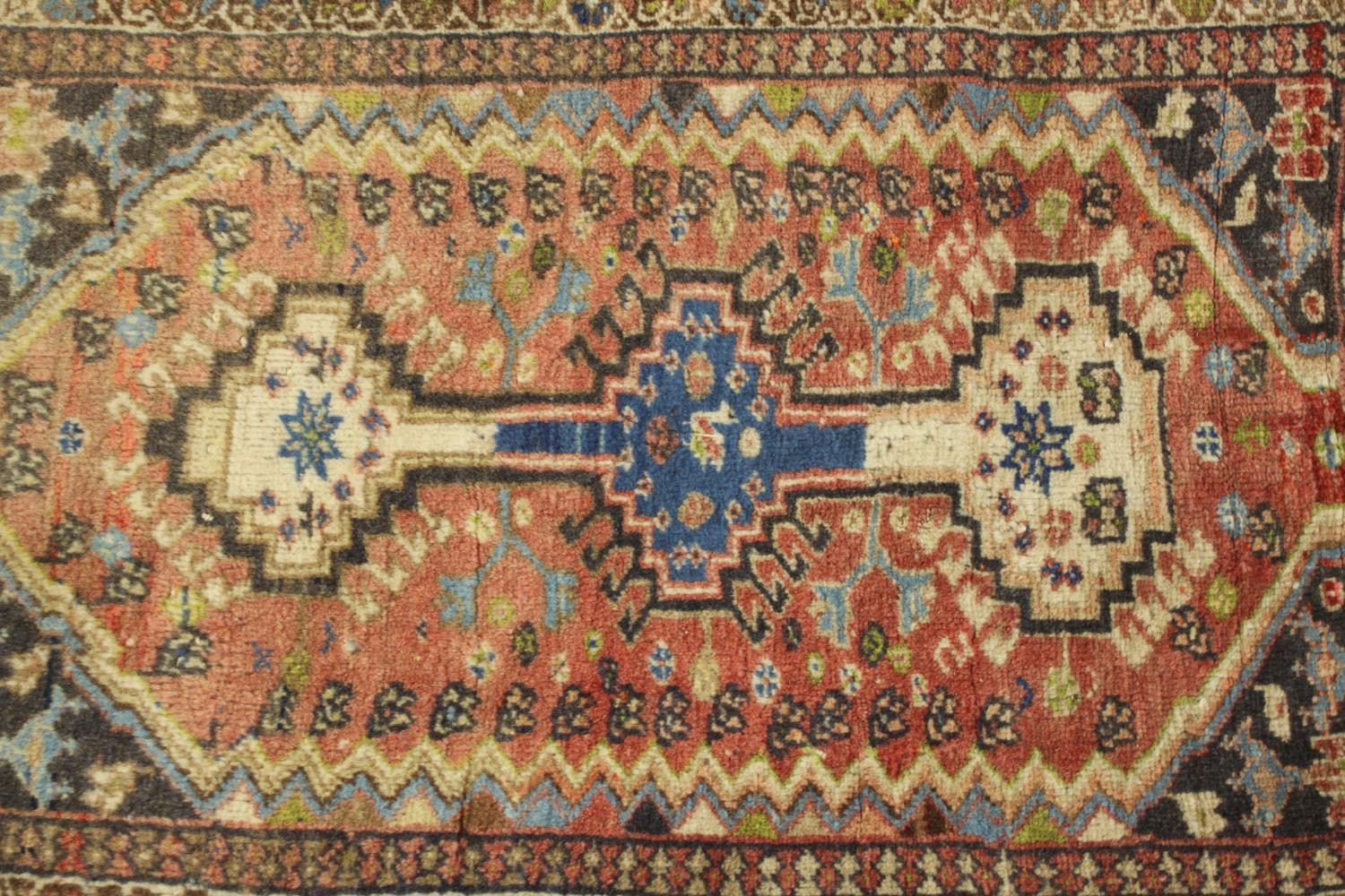 A hand woven red ground Persian Quashqai rug. L.88 W.53cm. - Image 3 of 5