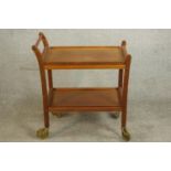 A circa 1960s teak two tier trolley of simple form on castors. H.74 W.70 D.42cm.