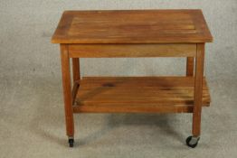 A slatted teak trolley, of rectangular form with two tiers on castors. H.62 W.76 D.50cm.