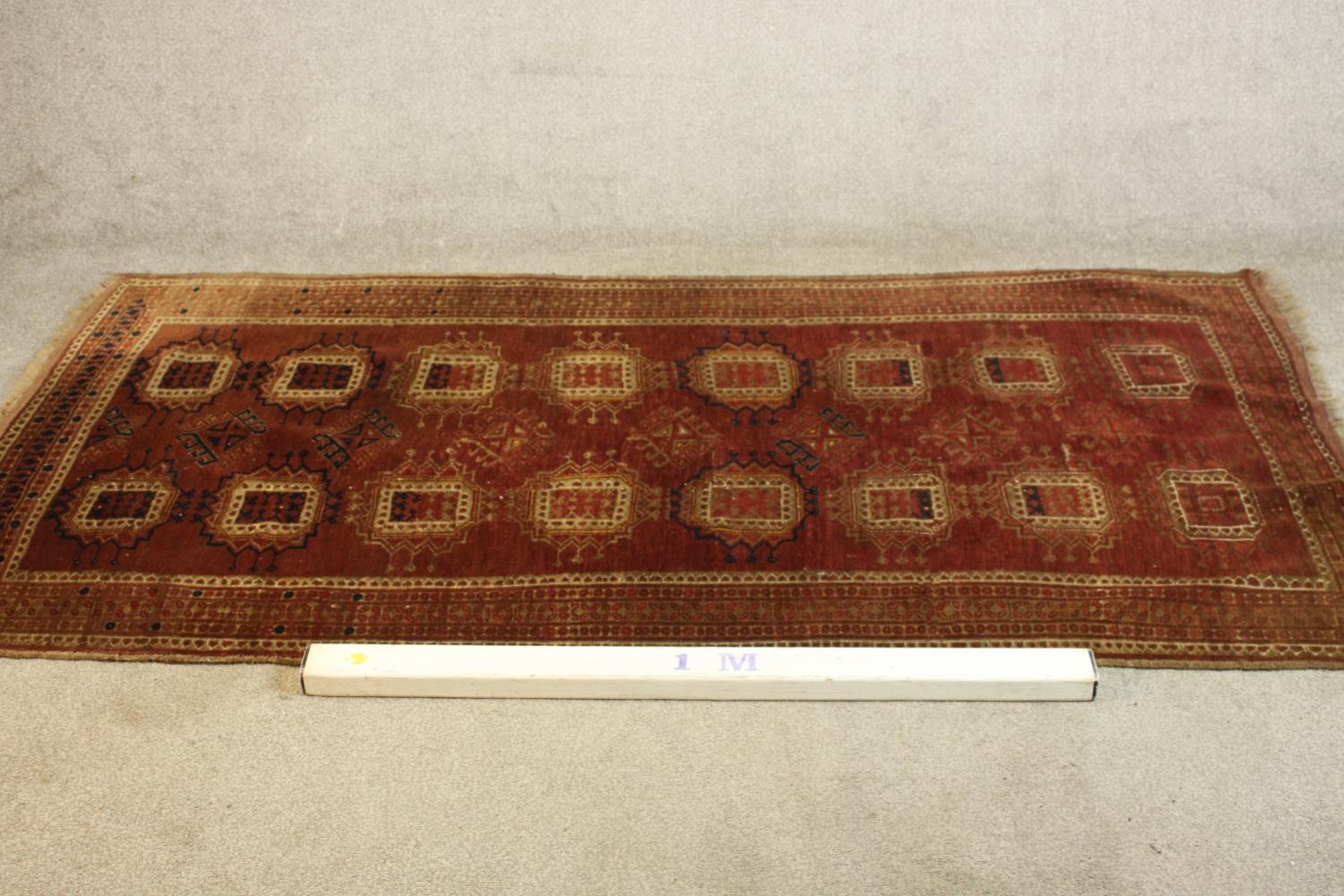 A hand woven Meshed carpet with repeating medallions on a burgundy field. L.210 W.113.cm. - Image 2 of 4