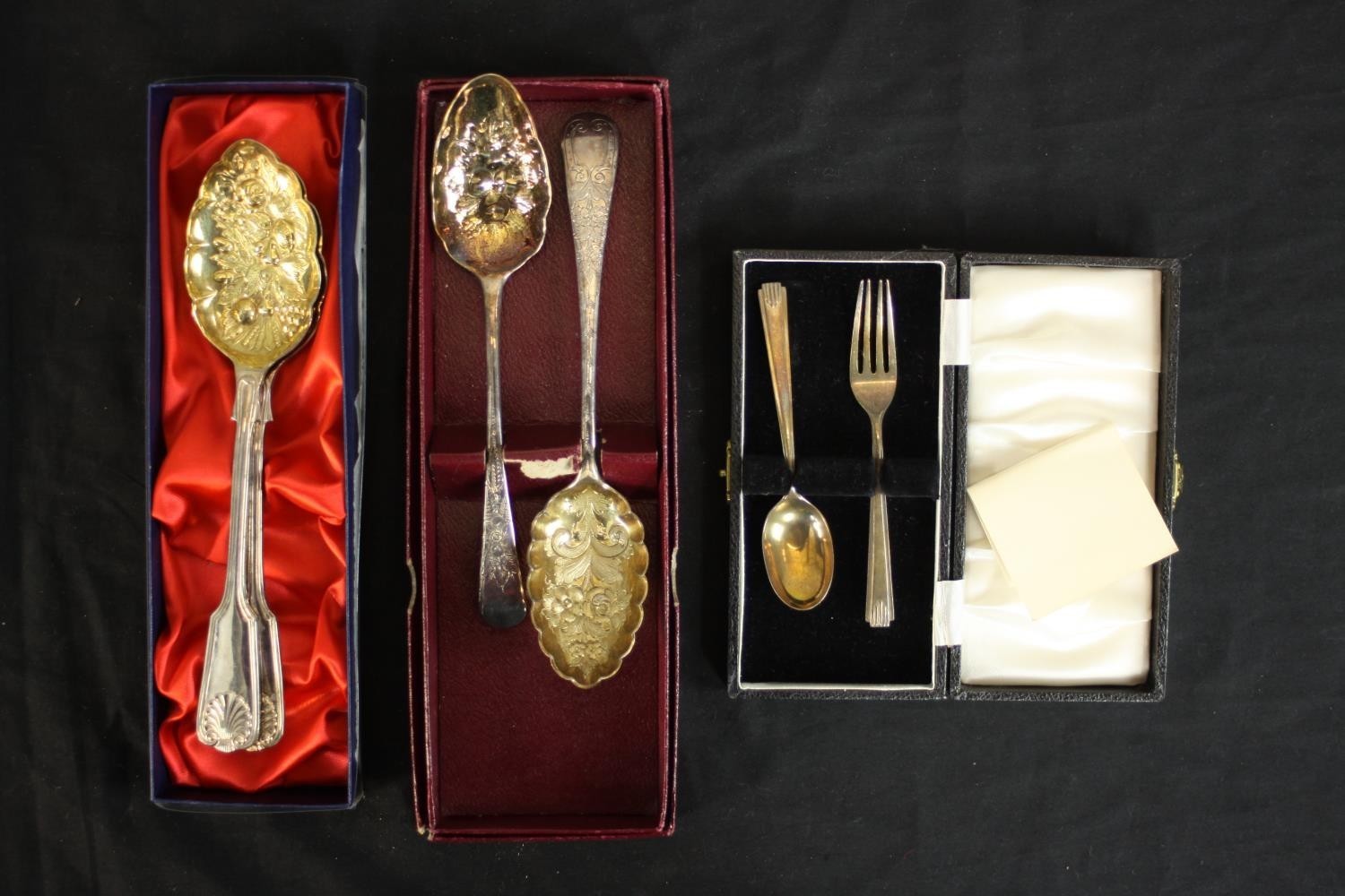 Two pairs of gilded silver plated berry spoons and a cased set of silver child's spoon and fork. (