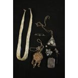 A collection of silver jewellery including a silver and garnet cat stick pin, a multi strand