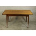 A circa 1960's teak dining table by Storys of Kensington, the rectangular top with cleated ends,