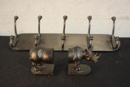 A cast iron set of six wall mounted coat hooks along with a pair of bronze effect resin Rhino