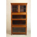 A mid 20th century mahogany Gumm stacking bookcase, with two glazed cupboard doors over three