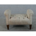 A contemporary dressing table stool, upholstered in light grey fabric with a buttoned seat and