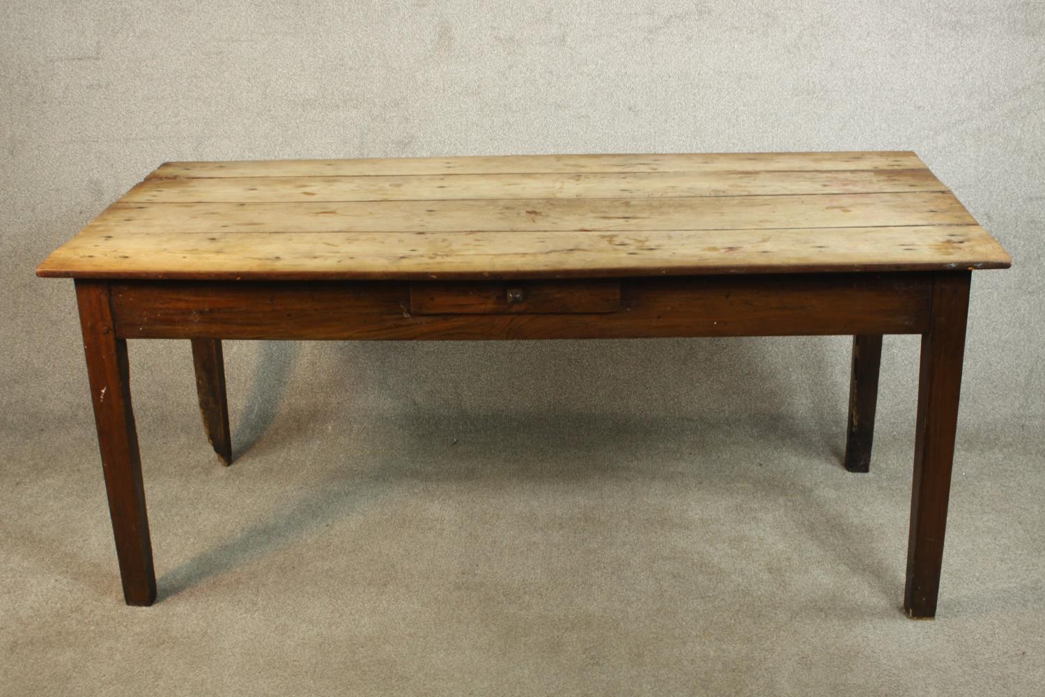 A 19th century French farmhouse table, with a plank top over a single drawer on square section