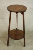 An Arts & Crafts oak lamp table, with a circular top on three pierced legs joined by a circular