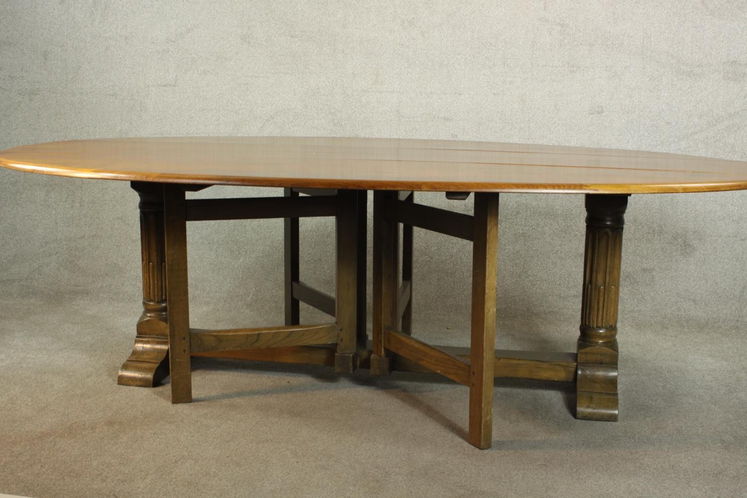 A 20th century oak drop leaf wake table, the oval top with two drop leaves raised on gate legs and - Image 8 of 12