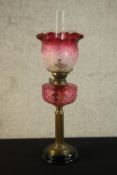 A Victorian paraffin oil lamp, with cranberry coloured reservoir, cranberry tinted acid etched shade