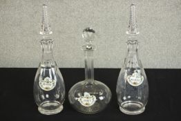 A pair of cut glass decanters with air twist design stoppers along with another decanter, each