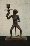 A painted spelter early 20th century candle holder in the form of a monkey holding a flower. H.31