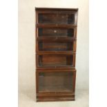 A Globe Wenicke stacking bookcase, of five tiers with rising glass doors on a plinth base, with