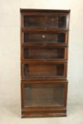 A Globe Wenicke stacking bookcase, of five tiers with rising glass doors on a plinth base, with