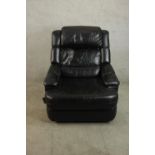 A late 20th century black leather reclining armchair, with padded seat and back cushions and a