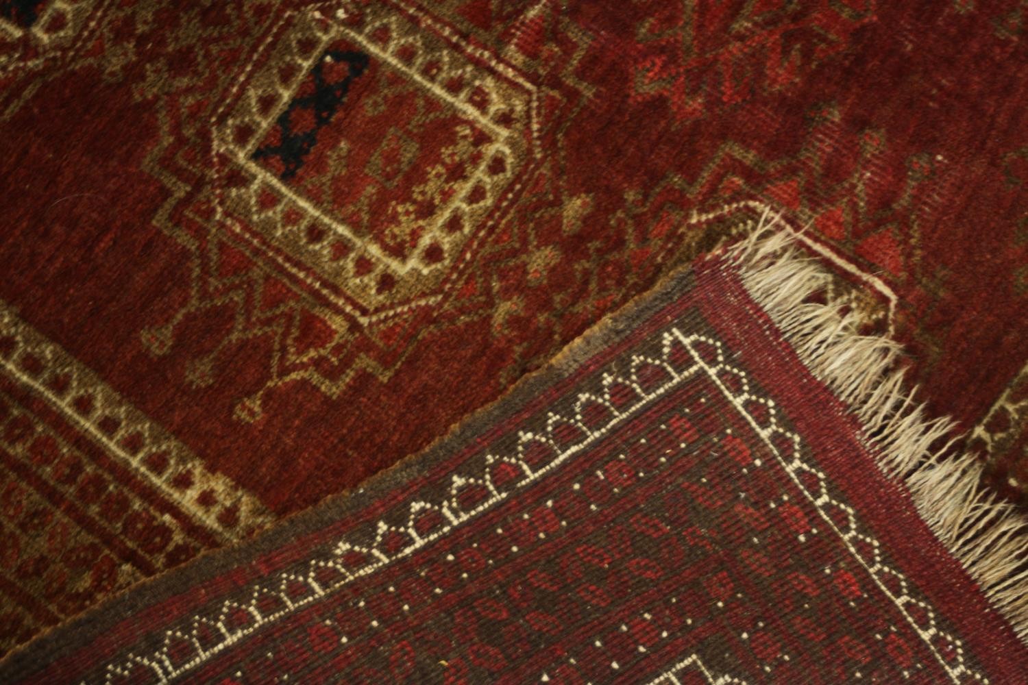 A hand woven Meshed carpet with repeating medallions on a burgundy field. L.210 W.113.cm. - Image 4 of 4