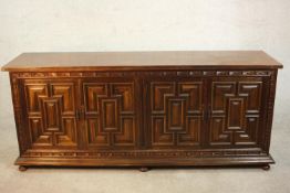 A 17th century style sideboard, the four cupboard doors with panelled decoration, on turned feet.