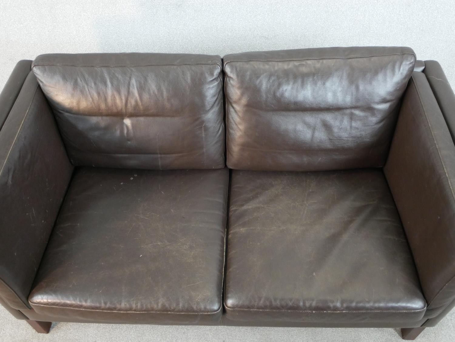 A 1970s Danish style two seater sofa, upholstered in dark brown leather, on square section legs. H. - Image 2 of 5