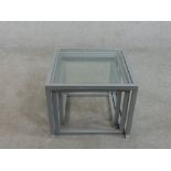 A contemporary nest of three occasional tables, of square form with plate glass tops and square