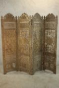 A 20th century Indian carved and pierced hardwood four fold screen, carved with many fruiting vines,