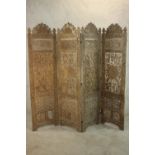 A 20th century Indian carved and pierced hardwood four fold screen, carved with many fruiting vines,