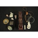 A collection of items including a carved bone Maori pendant, polished ammonite, two ceramic