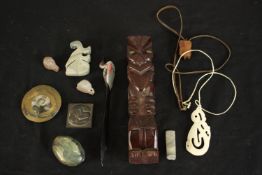 A collection of items including a carved bone Maori pendant, polished ammonite, two ceramic