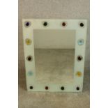 A contemporary rectangular mirror, the frame applied with coloured glass cabochons. H.80 W.60cm.