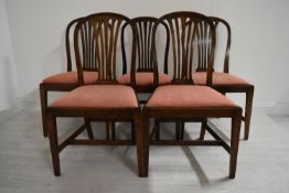 A set of five mahogany framed hoop and pierced splat back dining chairs with drop in seats raised on