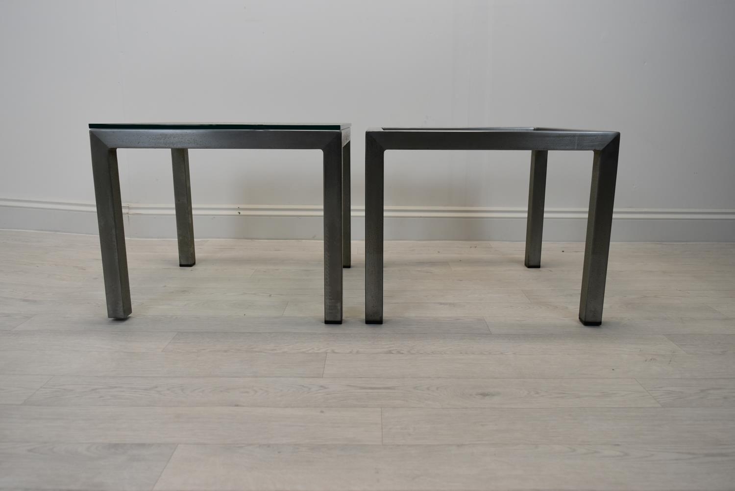 A pair of square brushed metal framed coffee side tables with glass top. Some chips to glass and one